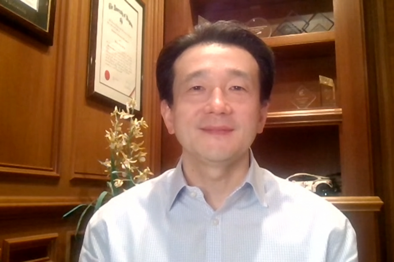 Man in dress shirt with bookcase in background