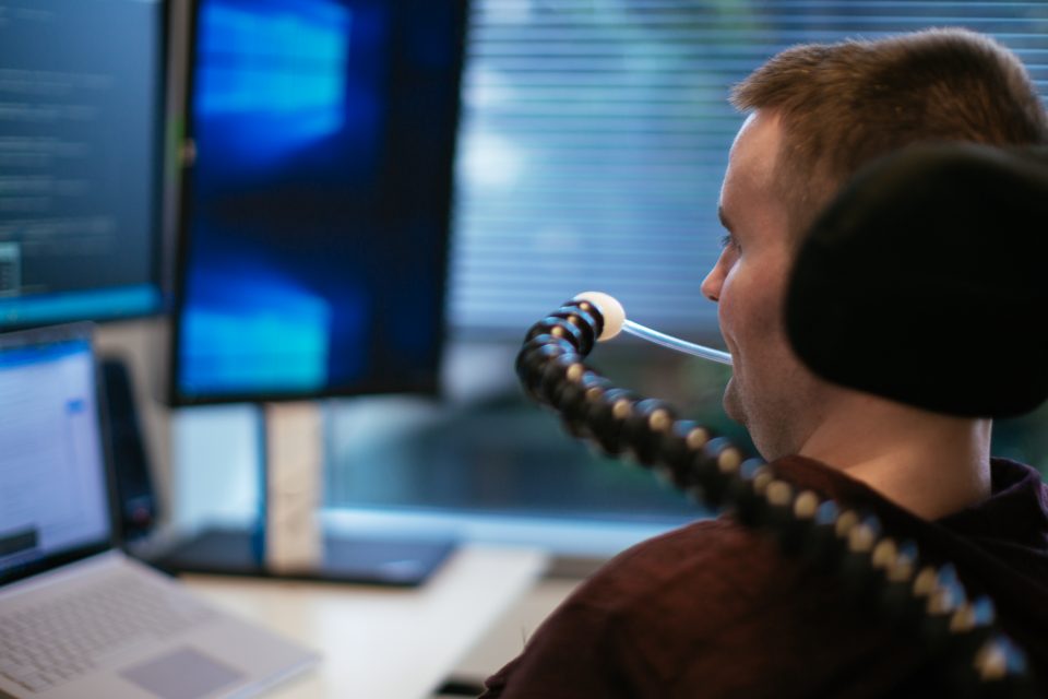 Persona con discapacidad trabajando con un portátil y mirando pantalla
