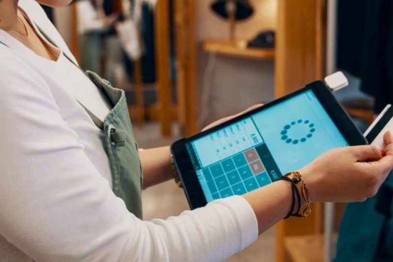  A person holds a tablet and a credit card