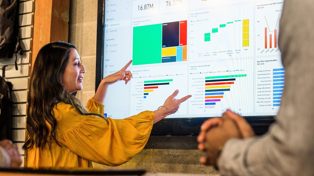 Two people work together on a large computer screen