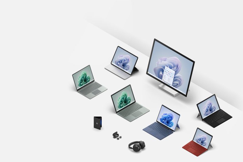 Seven computers, one set of earbuds, one set of headphones and one dual-screen smartphone are arranged next to each other.