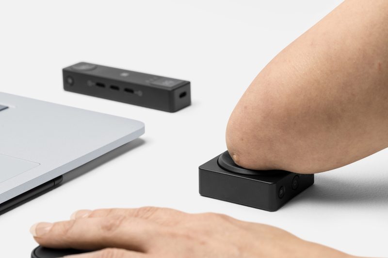 A person uses a mouse and input accessory to control their computer.