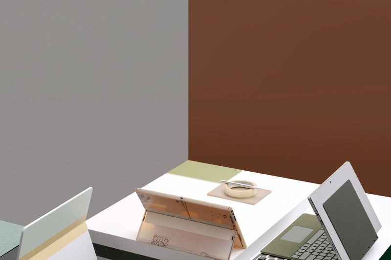 Two plastic PC prototypes sit on a desk next to a functioning prototype as well as a kitchen grater and mouse prototype.