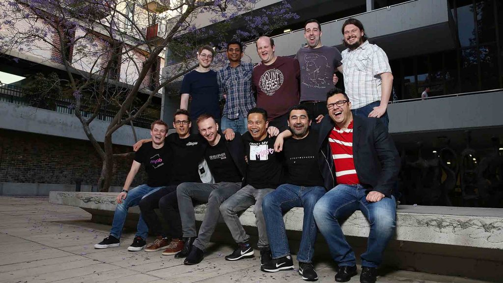 Numerous hackers posing outside an office building