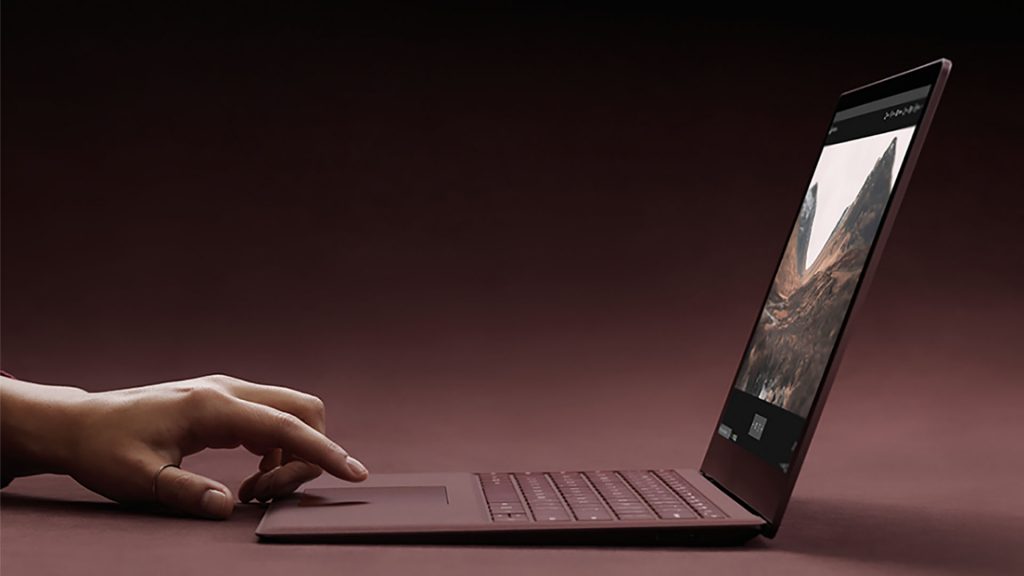 Hand poised over the touch pad of Surface device