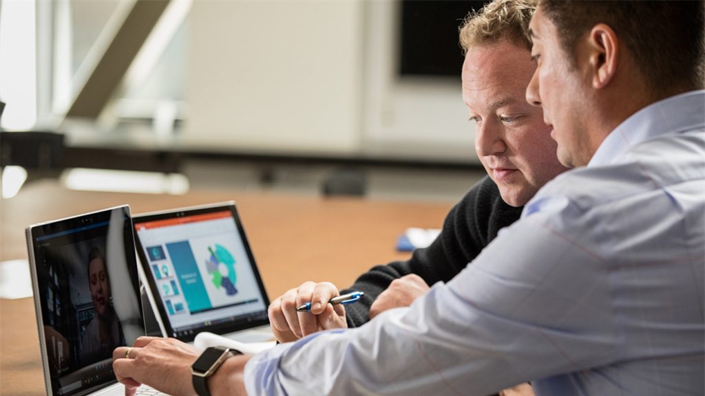 Two men looking at a laptop