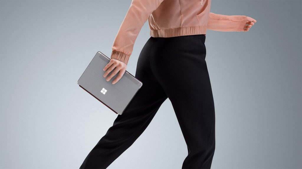 woman holding surface go while walking