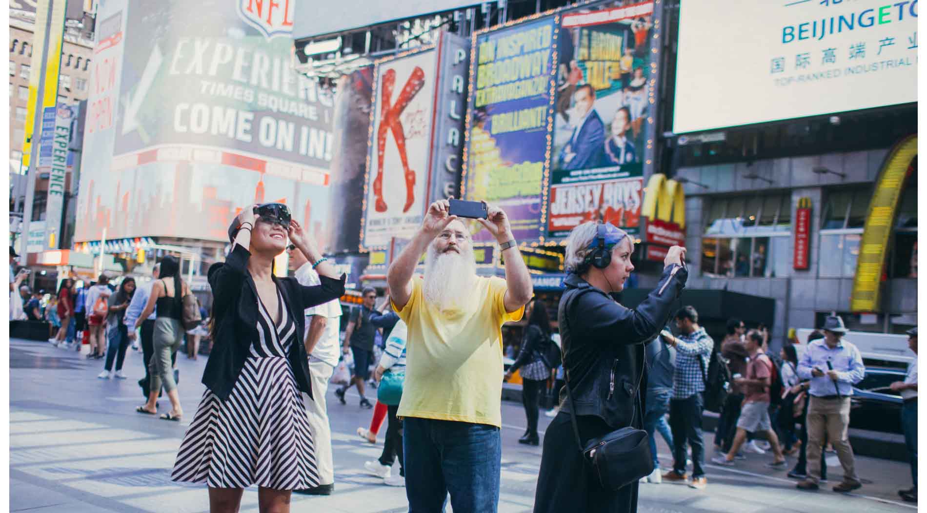 Three people in Times Square look at billboards using HoloLens