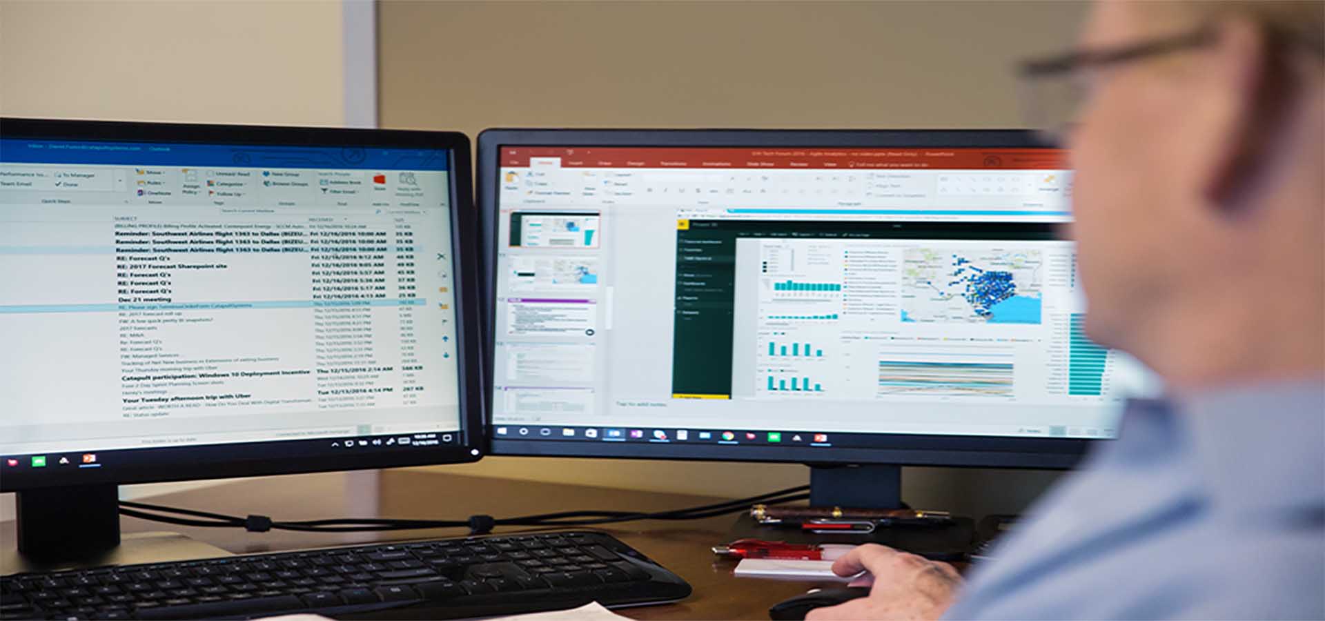 man looking at emails and charts on computer screen