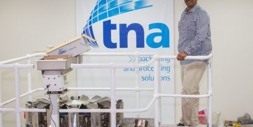 Pravin Singh standing infront of TNA sign
