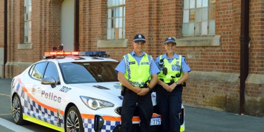 Police officers standing infront of police car