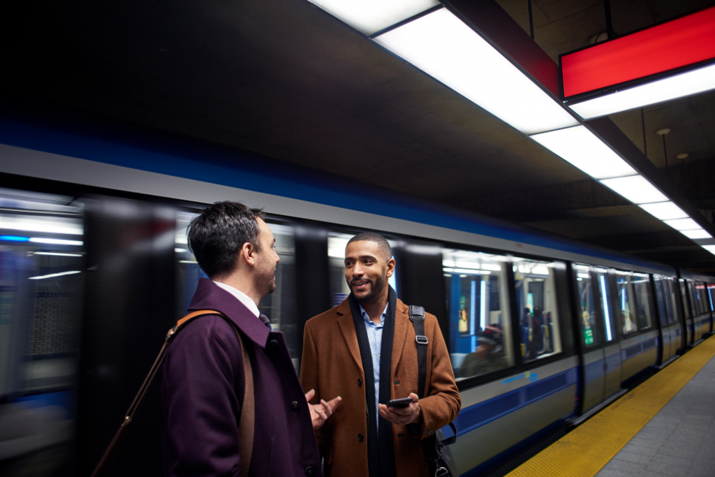 Image of two men standing at train station