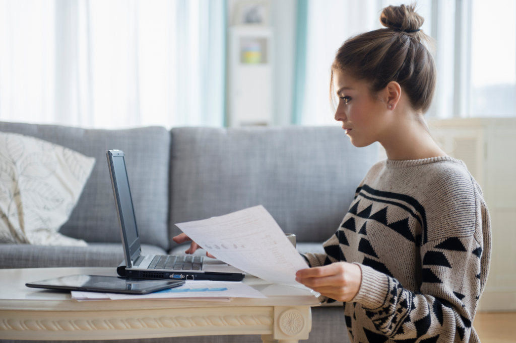 Young woman working with laptop in living room.