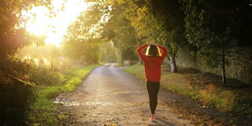 Woman in jogging clothes with sunlight peaking through the frame