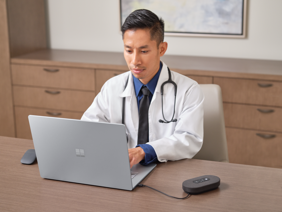 Male doctor sitting at a desk working on a Laptop 4.