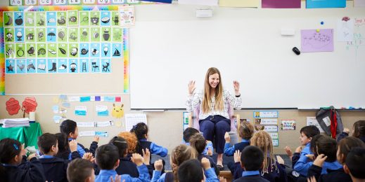 Female school teacher infront of a class of young students
