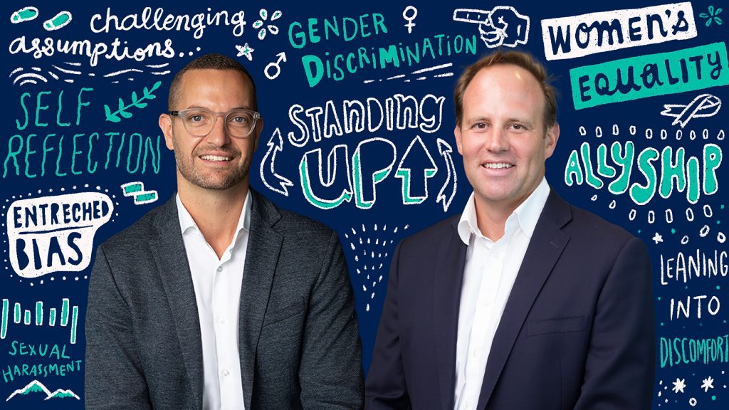 Two adult men infront of a background filled with graphical text