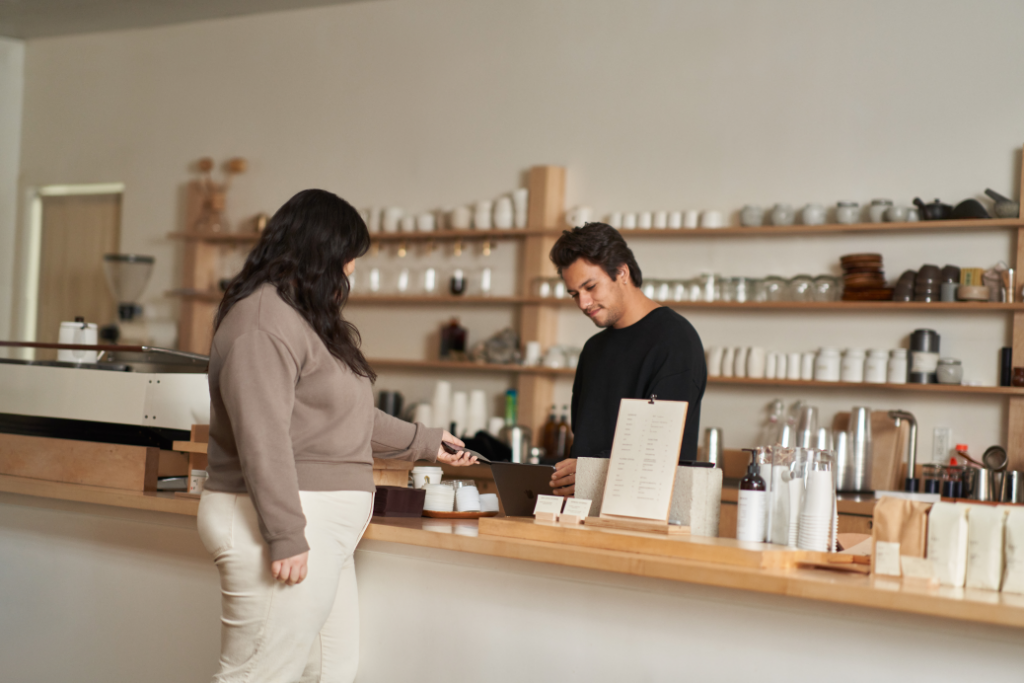 Customer using a mobile device to make a secure coffee shop purchase