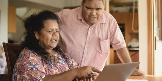 Mature couple using laptop with woman pointing
