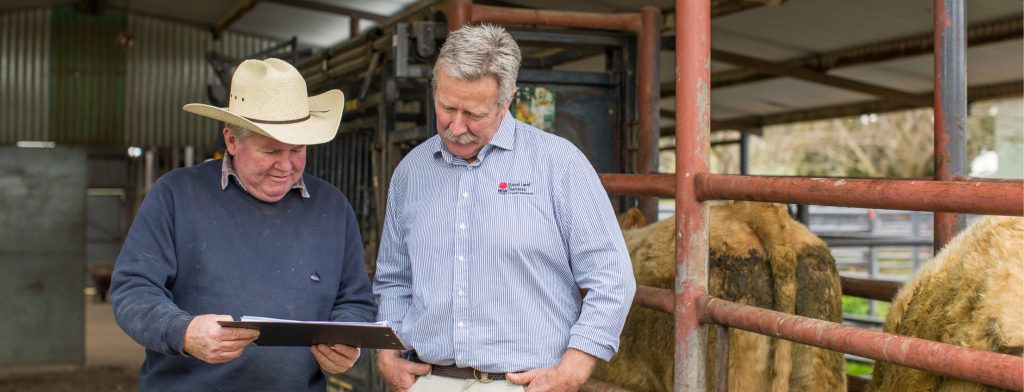 A farmer interacting with a local land services worker