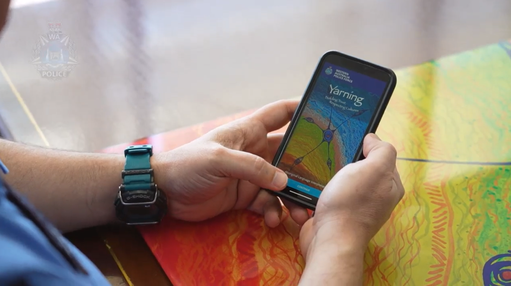 Adult man holding a phone with the Yarning app interface