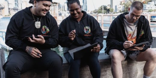Three adult Indigenous artists collaborating on a Microsoft Surface