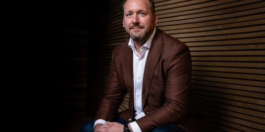 Adult caucasian man, wearing a maroon blazer and white business shirt
