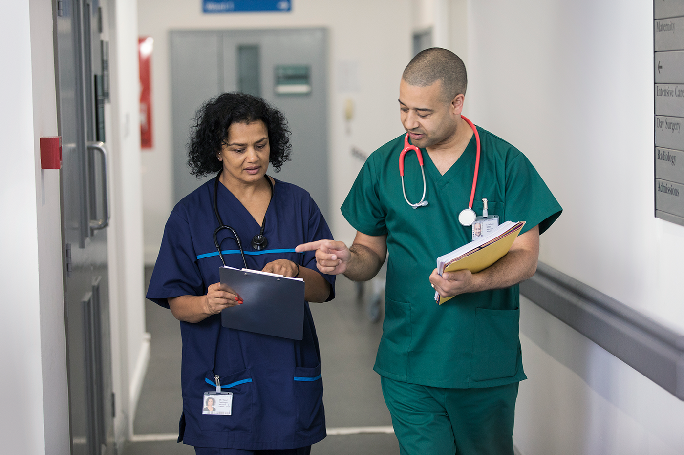 Two physicians walk down a hallway