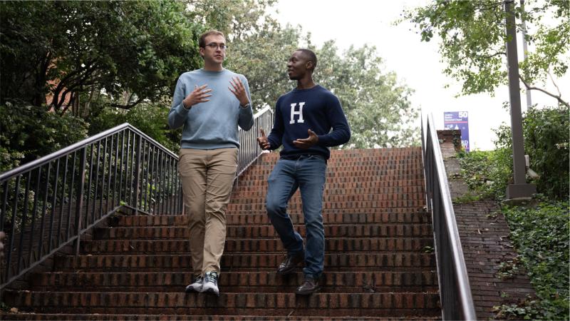Two men walk down the stairs