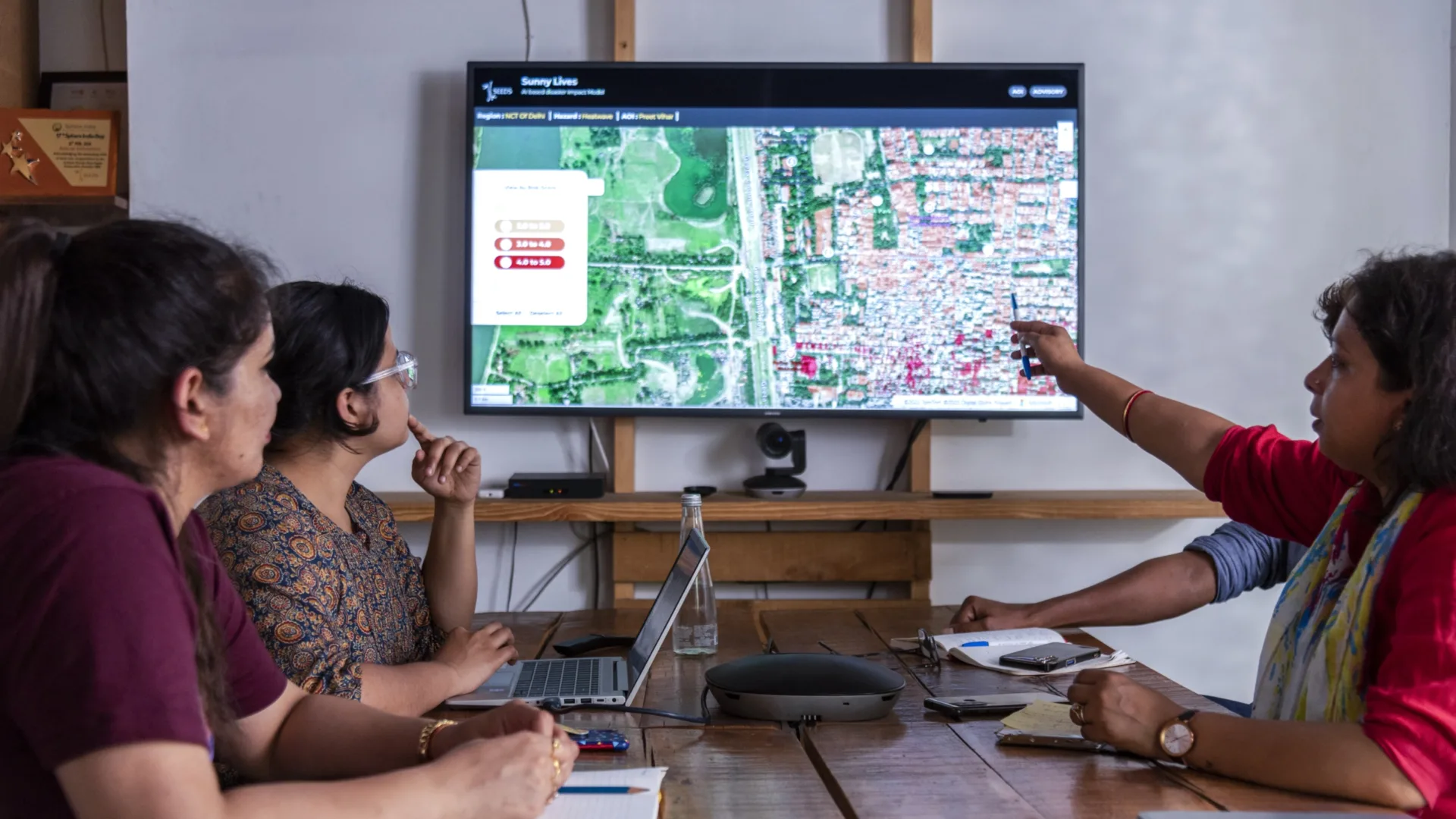Four people sit at a table during a meeting