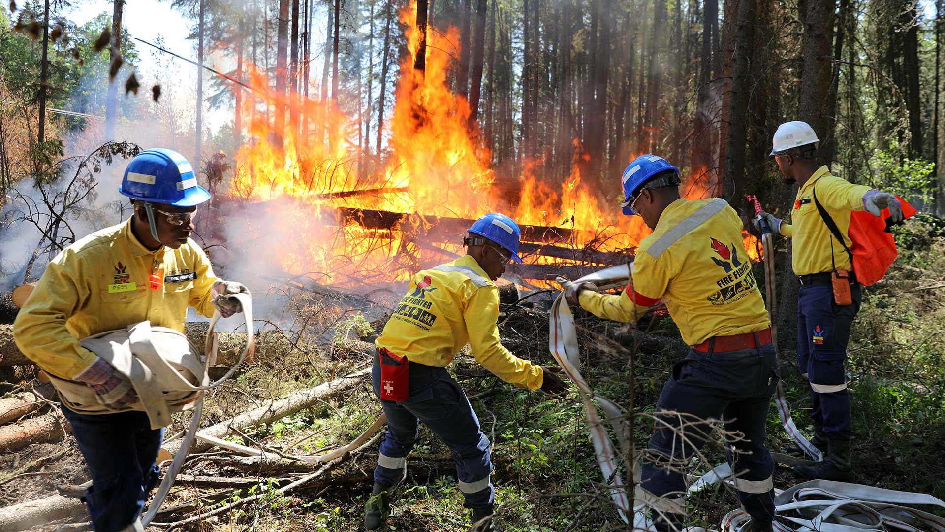 Four people work to put out a fire