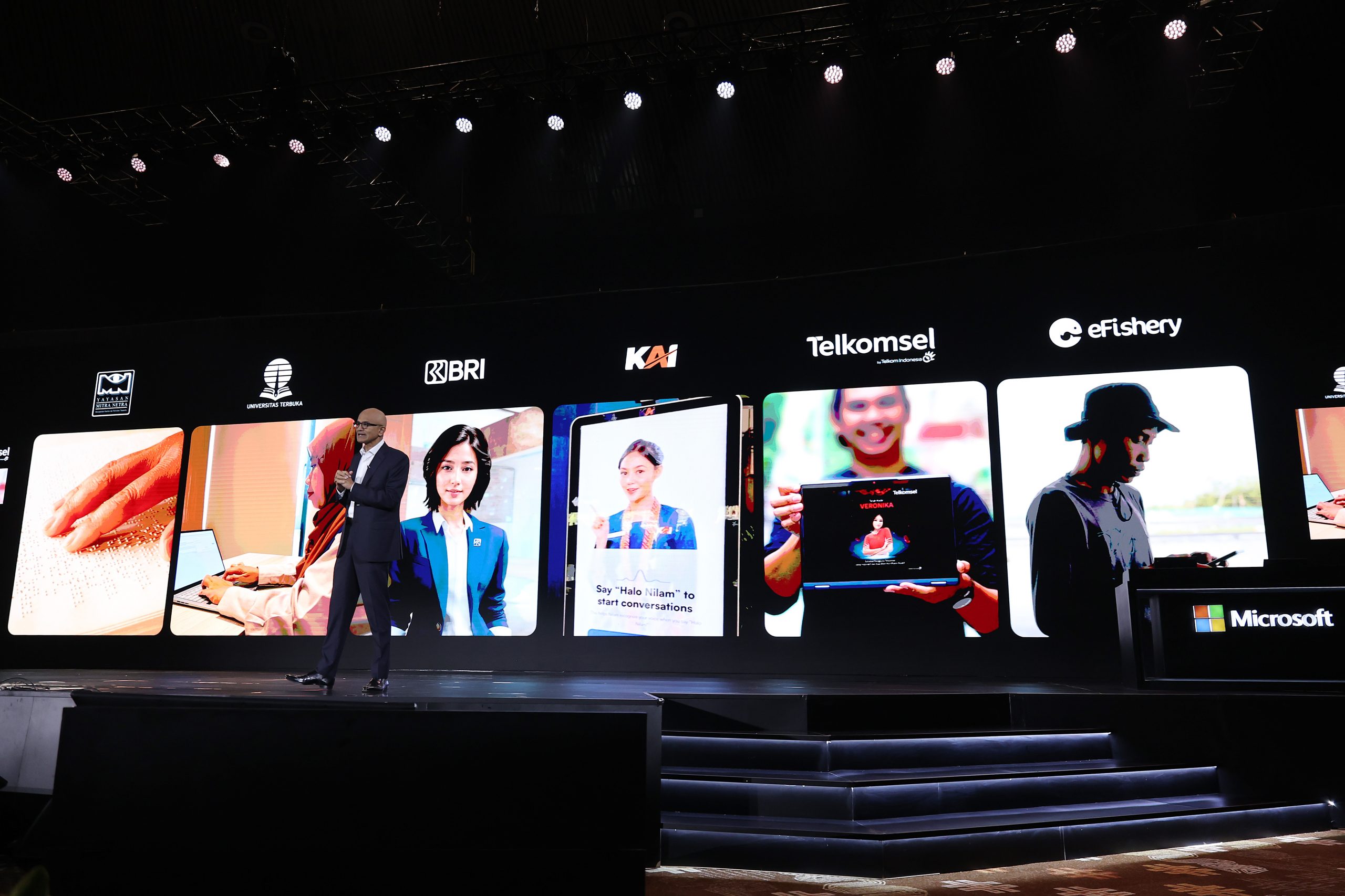 Man on a stage with a large digital backdrop