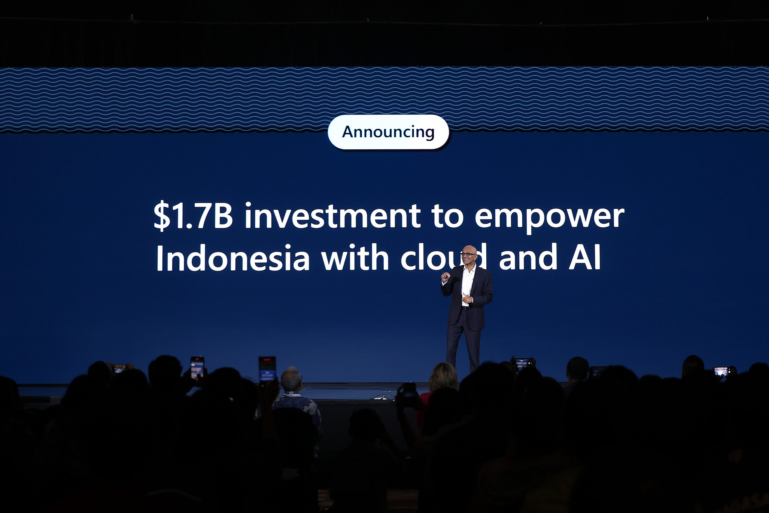 A man on stage making an investment announcement in Indonesia