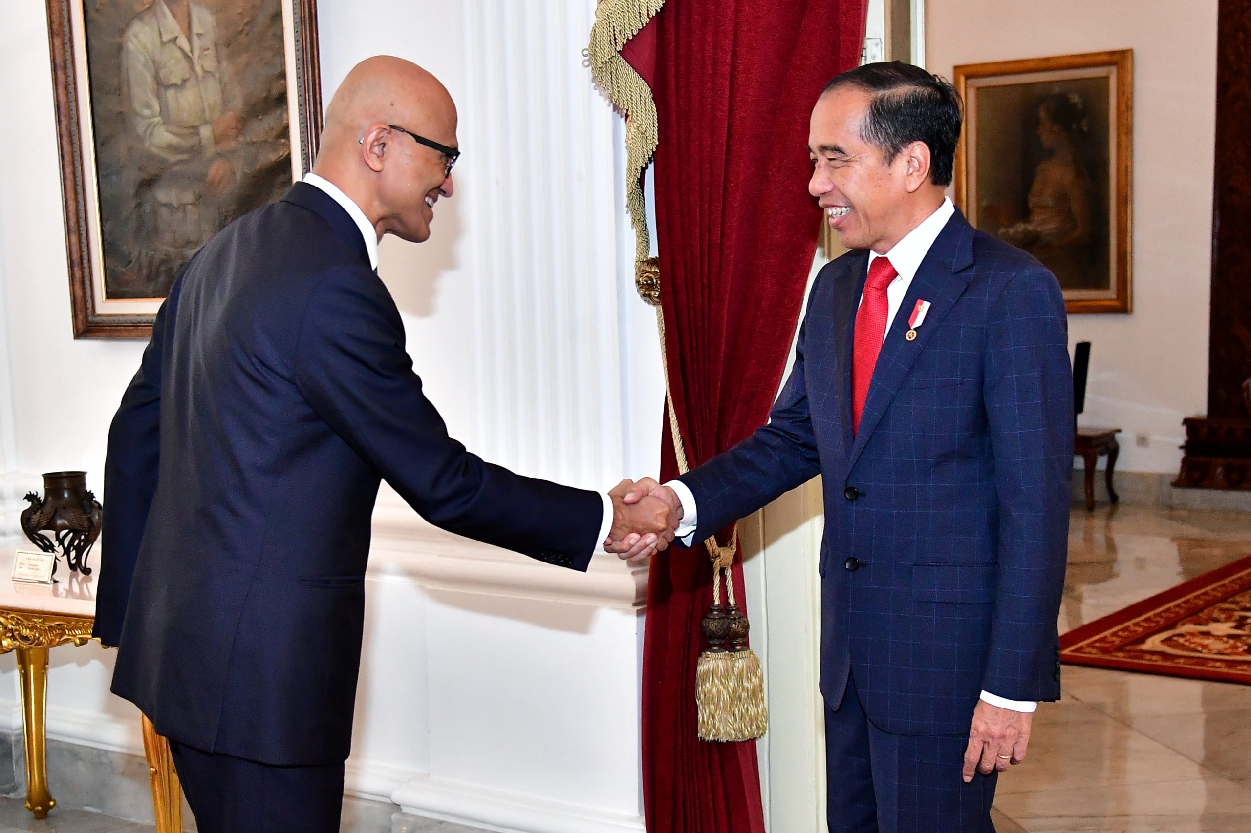 Two men dresses in suits shaking hands