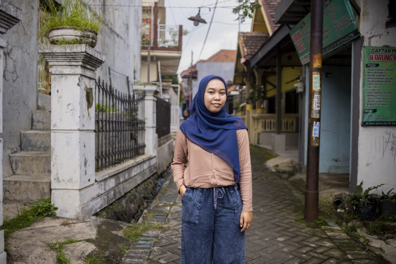 Woman in headscarf standing in a lane