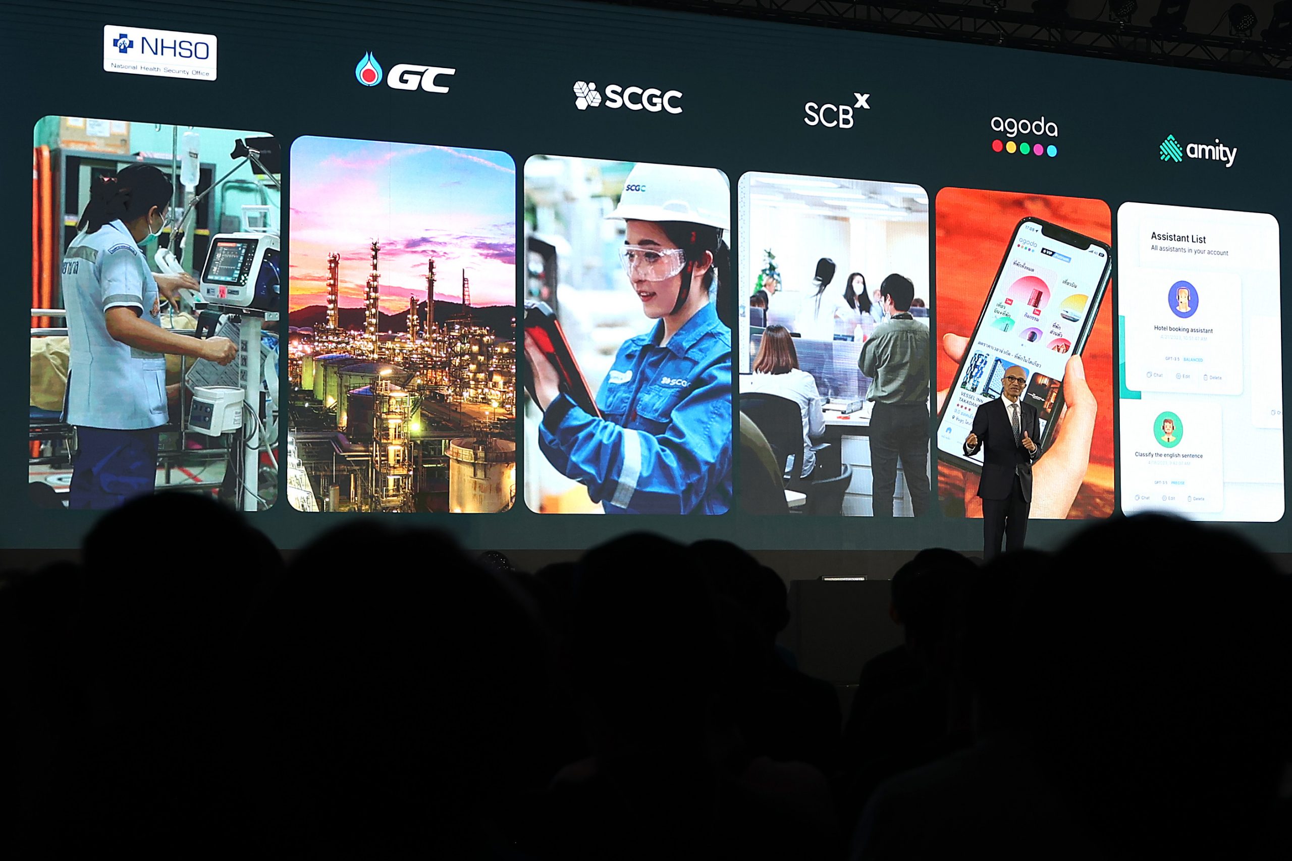 Man on stage against a backdrop with panels on it