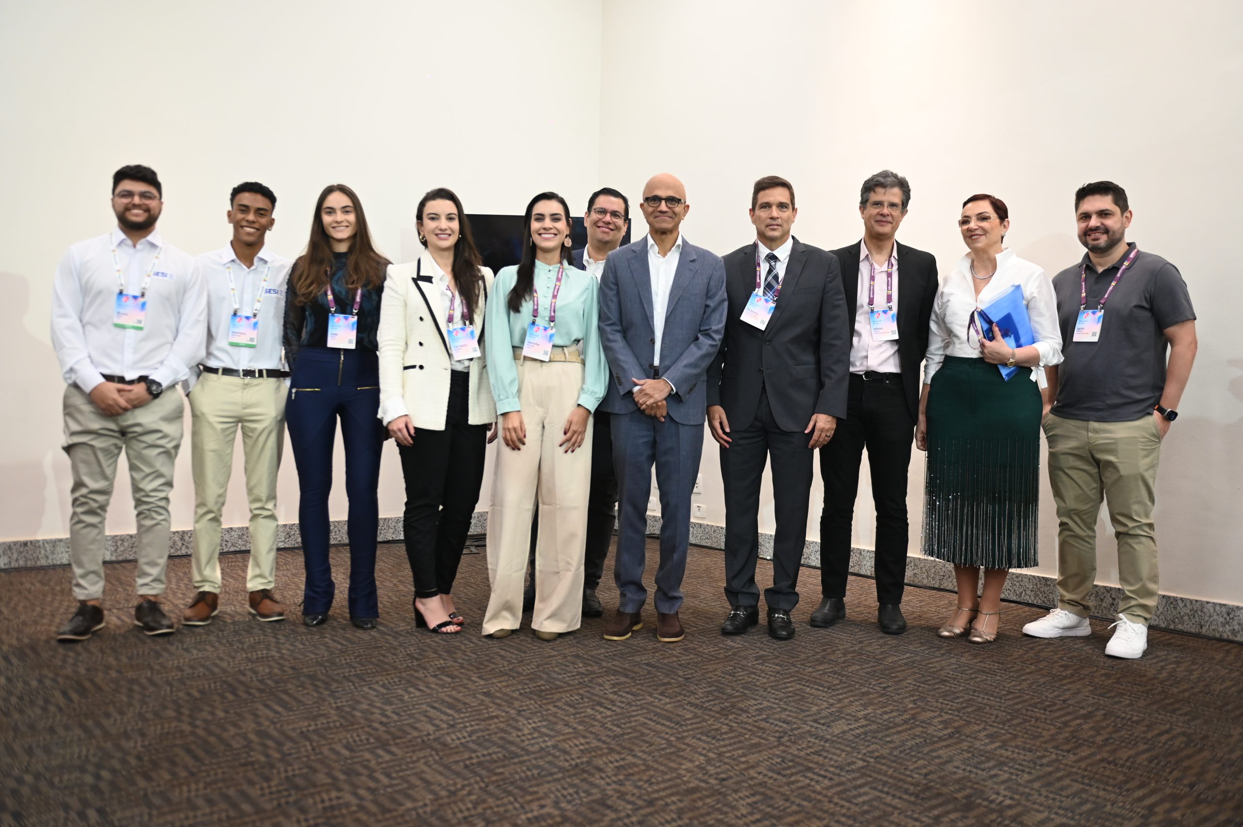 Um grupo de pessoas está lado a lado posando para uma fotografia