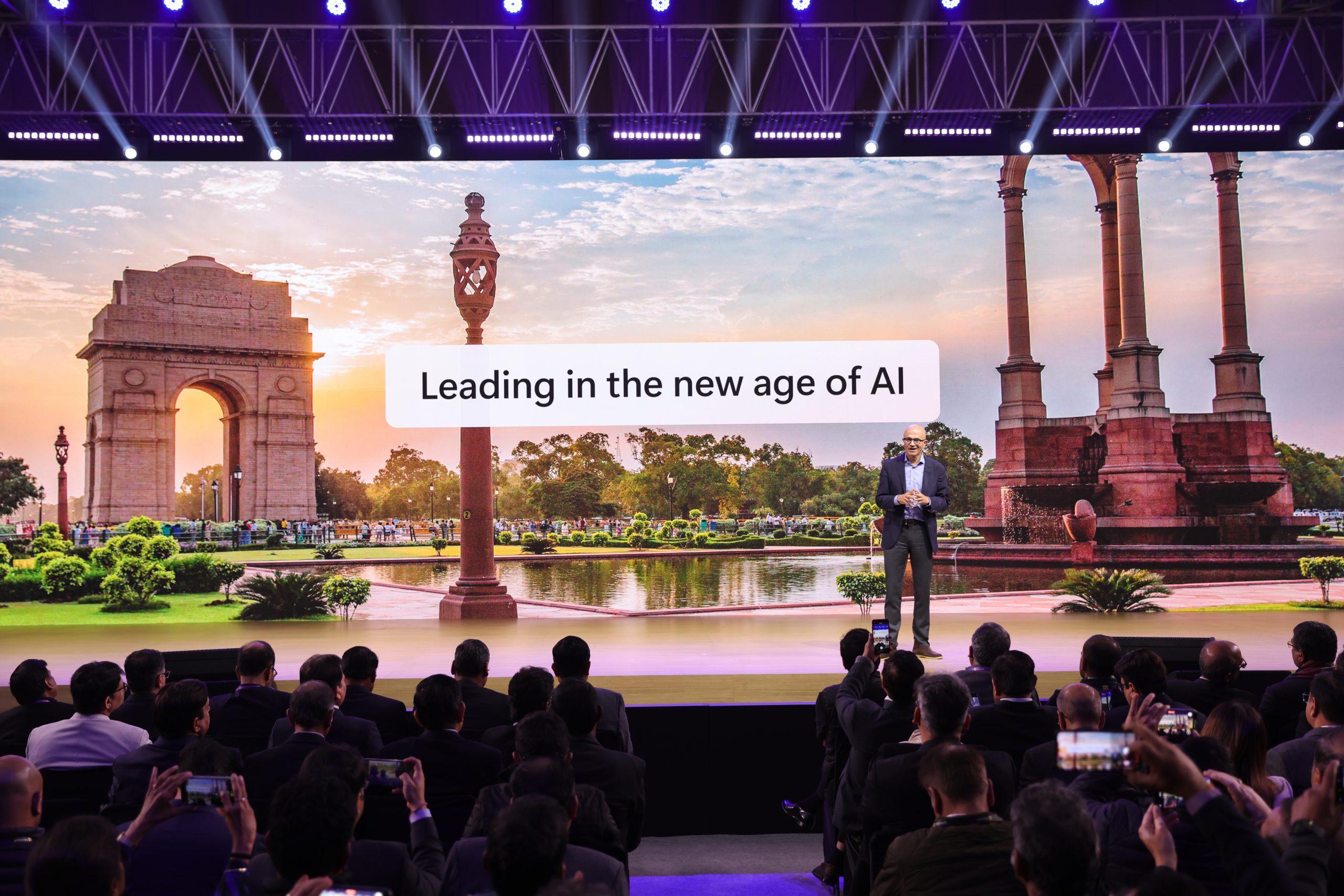 Man on stage with backdrop that says leading in the new age of AI