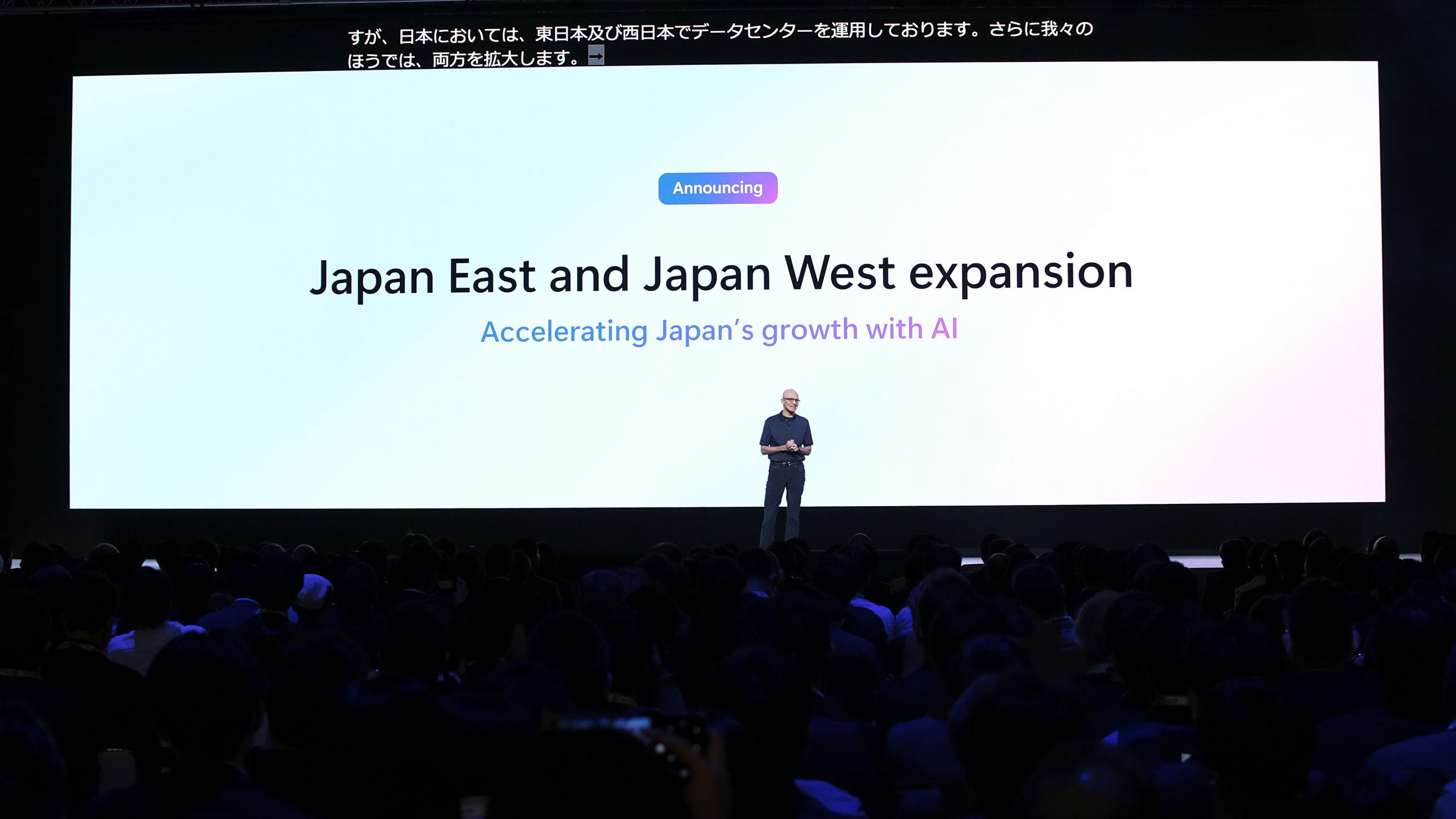 男性がイベントのステージ上でプレゼンテーションをしている