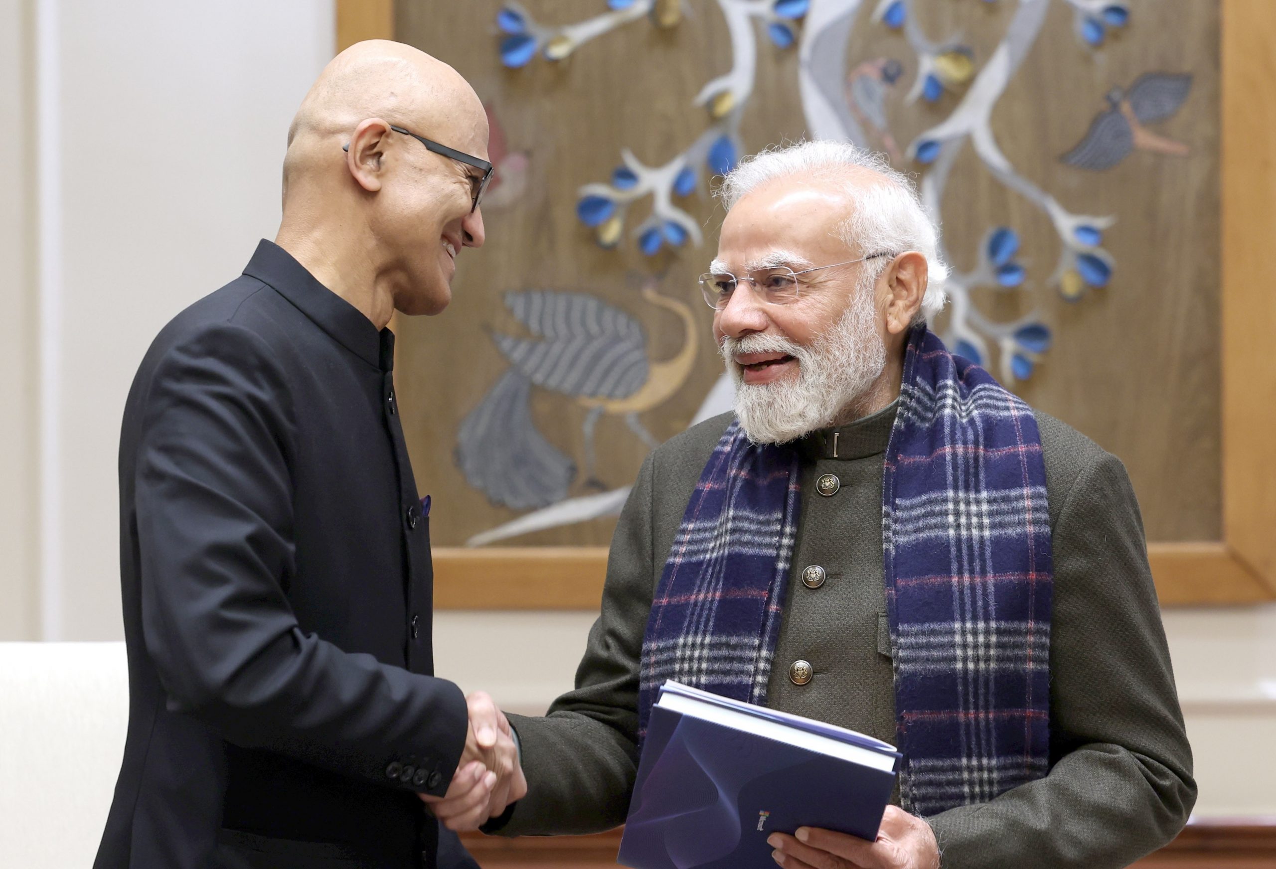 Two men in formal attire shaking hands
