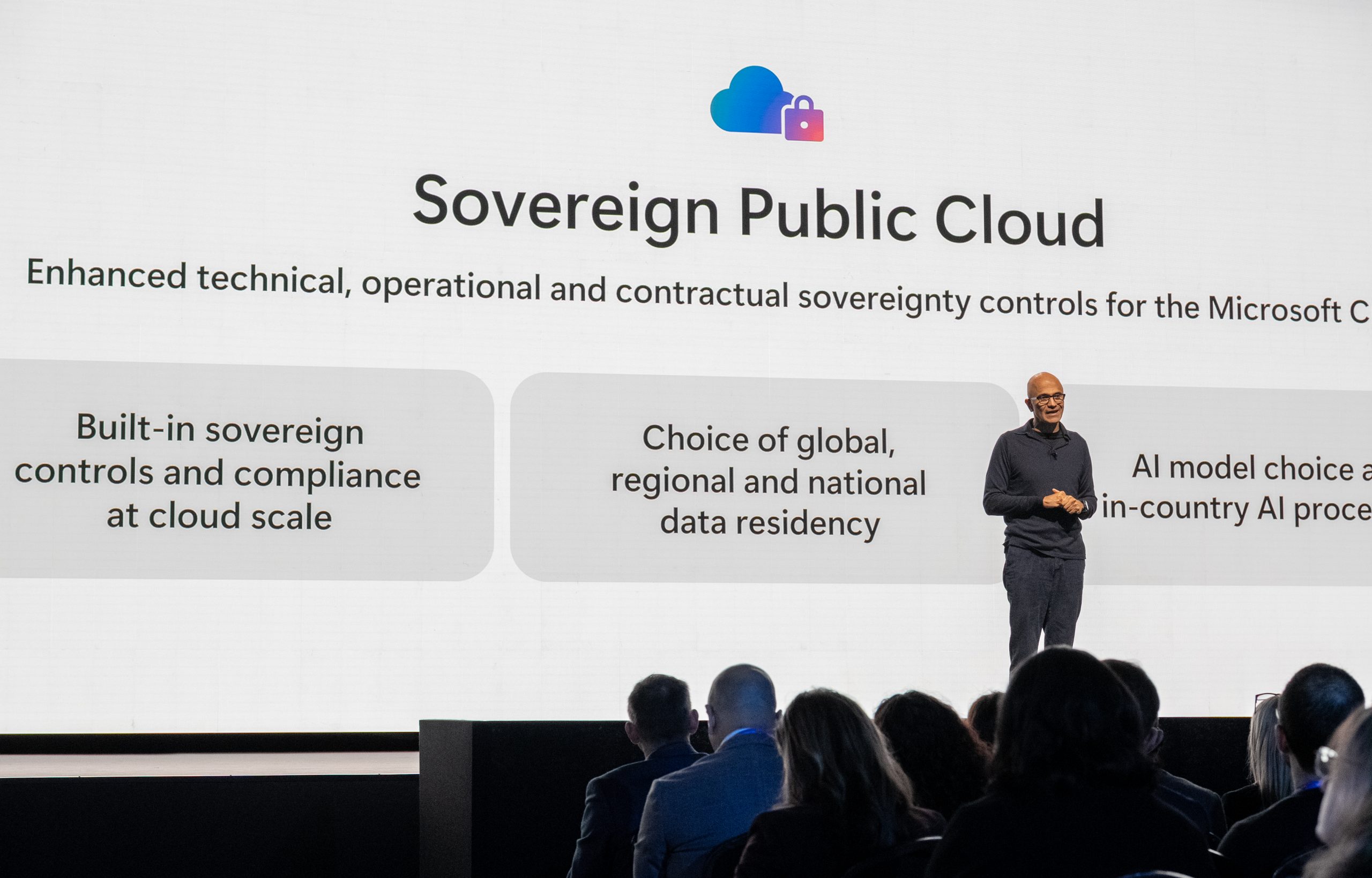 Satya Nadella standing before a Sovereign Public Cloud display during conversations on AI transformation.