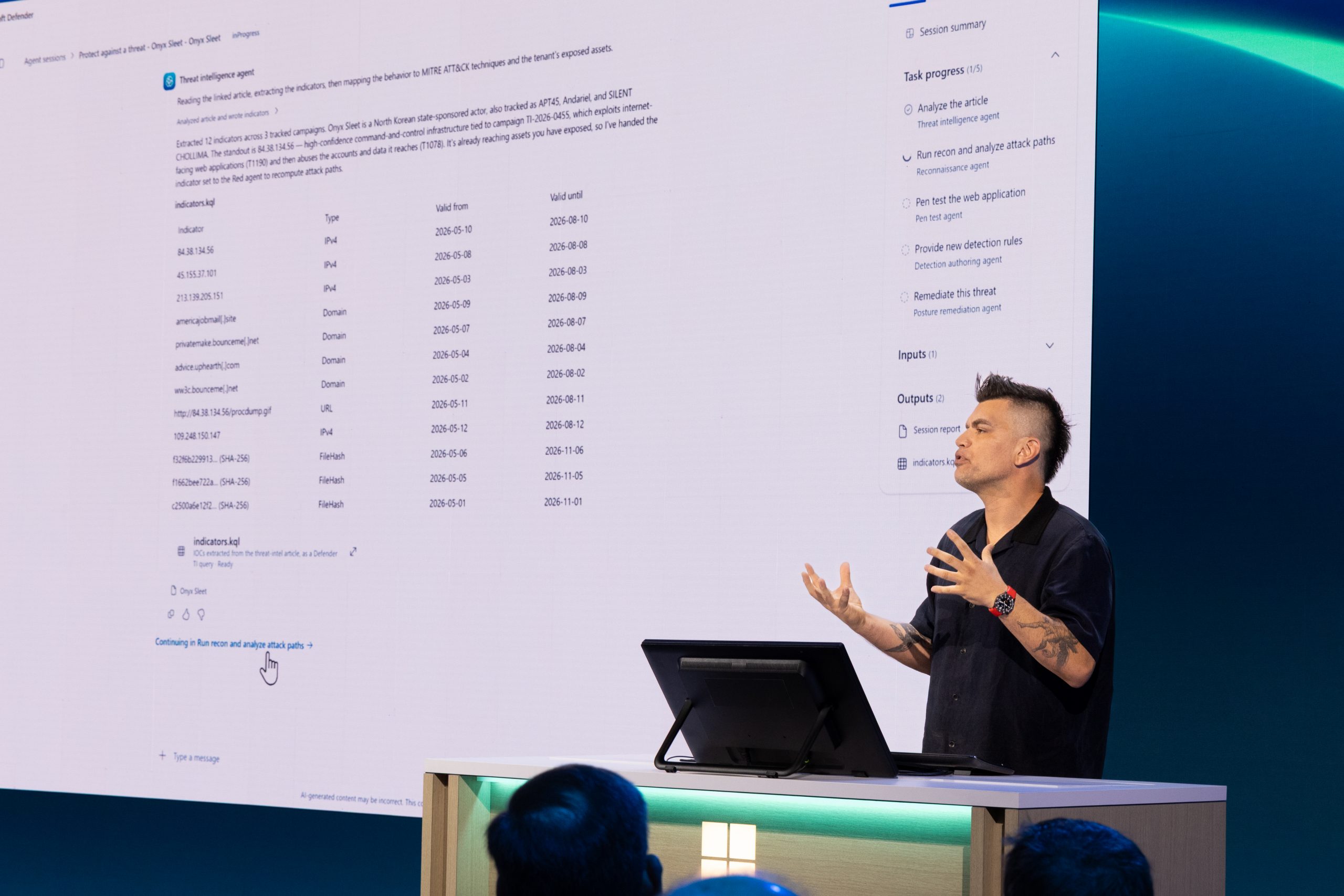 A man speaks onstage during a presentation.