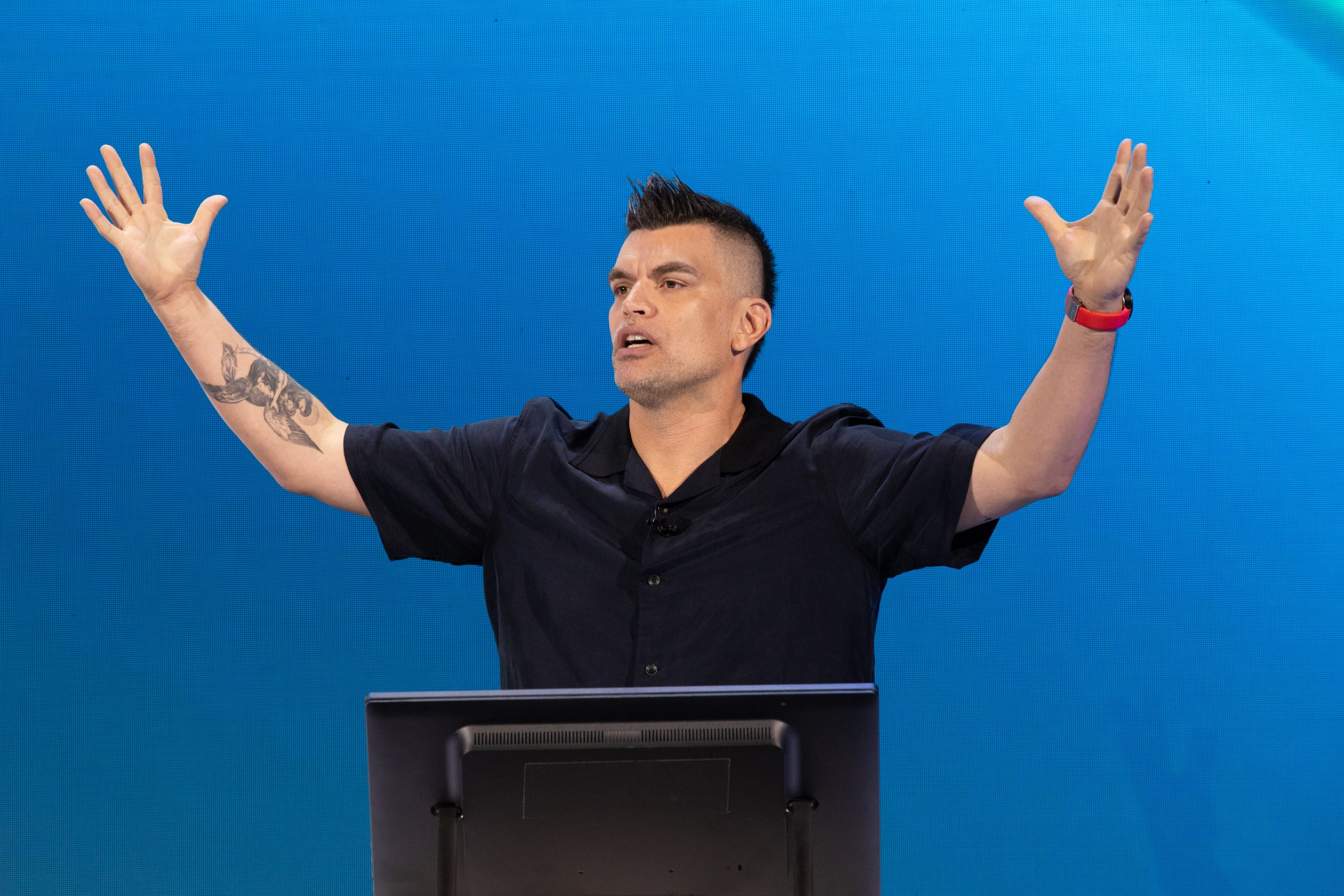 A man speaks onstage during a presentation.