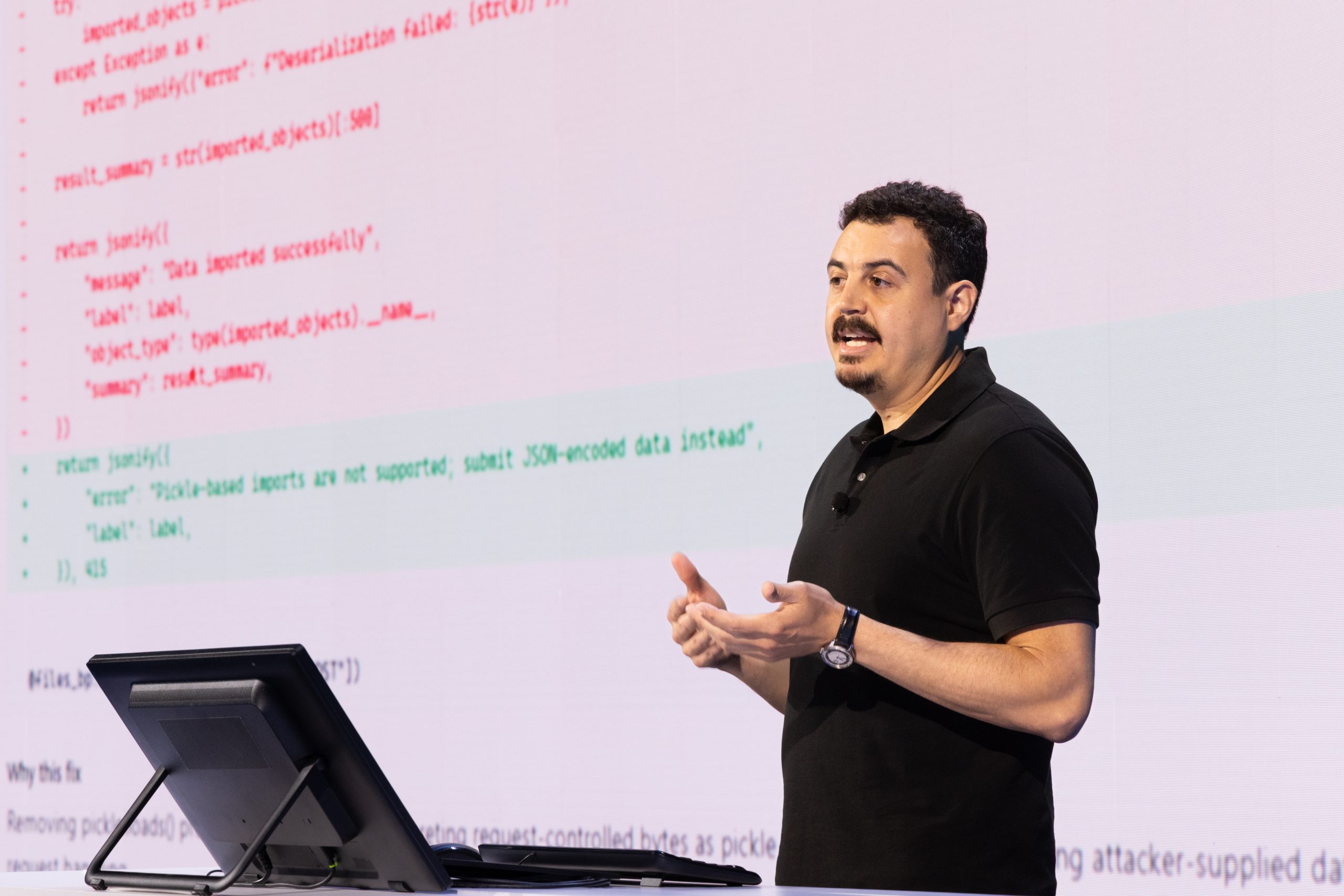 A man speaks onstage during a presentation.