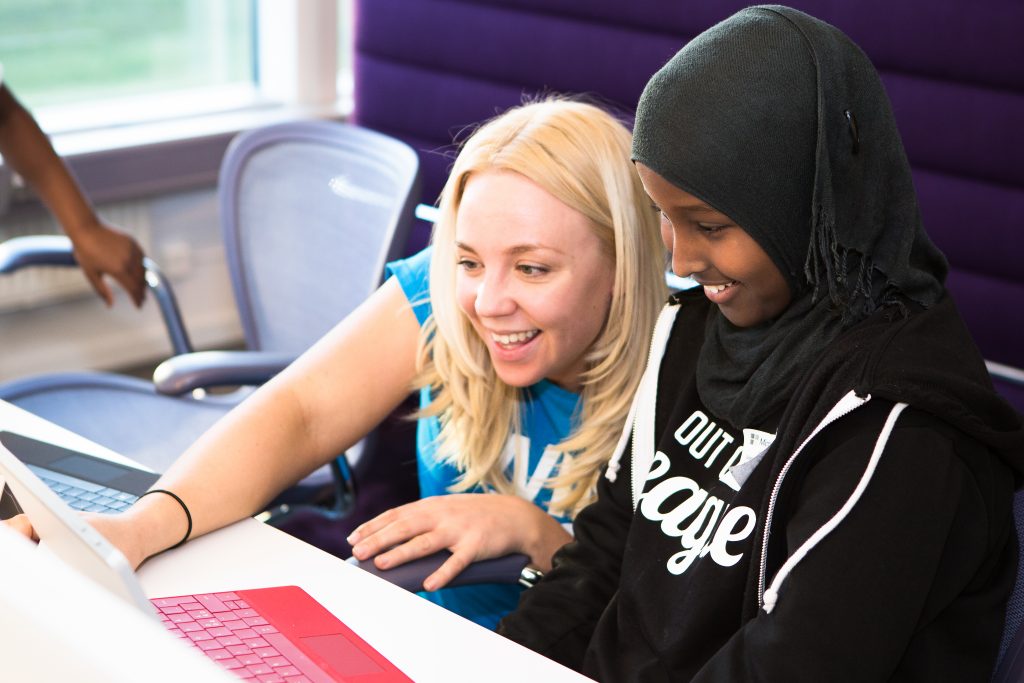 Two children learning to code on a laptop