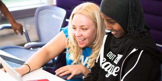 Two children learning to code on a laptop