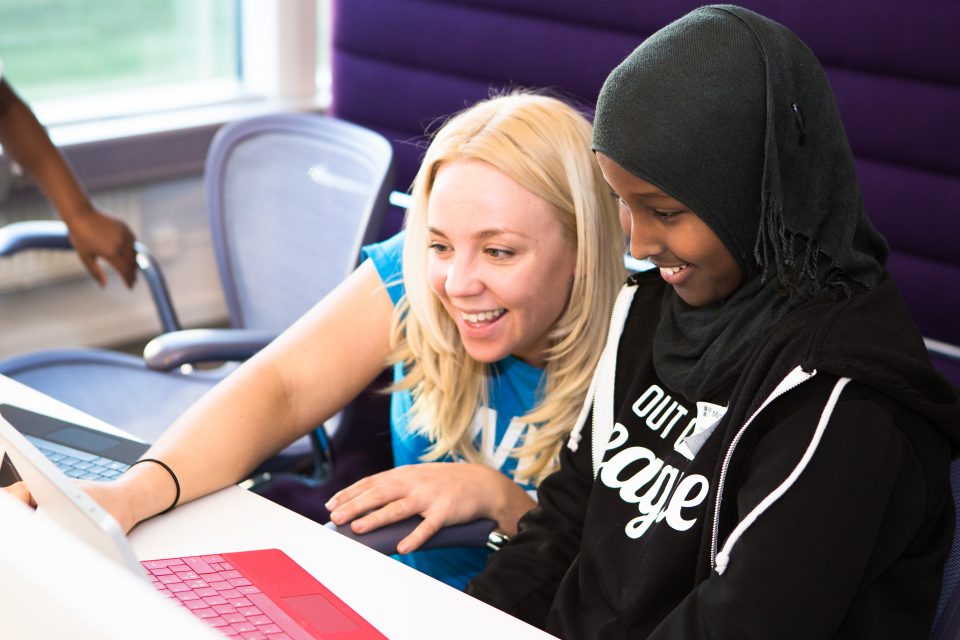 Two children learning to code on a laptop