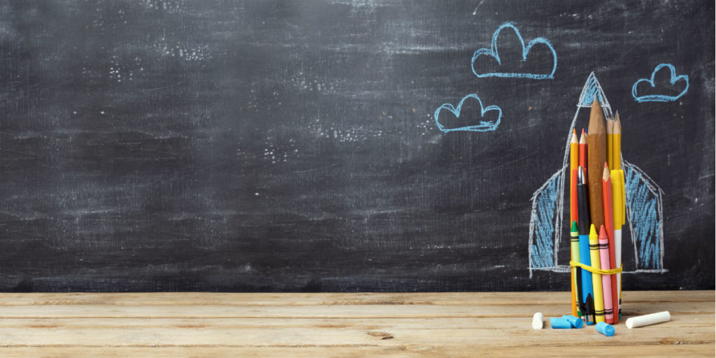 Back to school concept with rocket made from pencils over chalkboard background