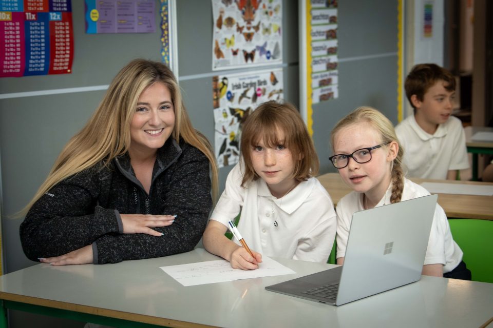 Teacher with two pupils at a laptop